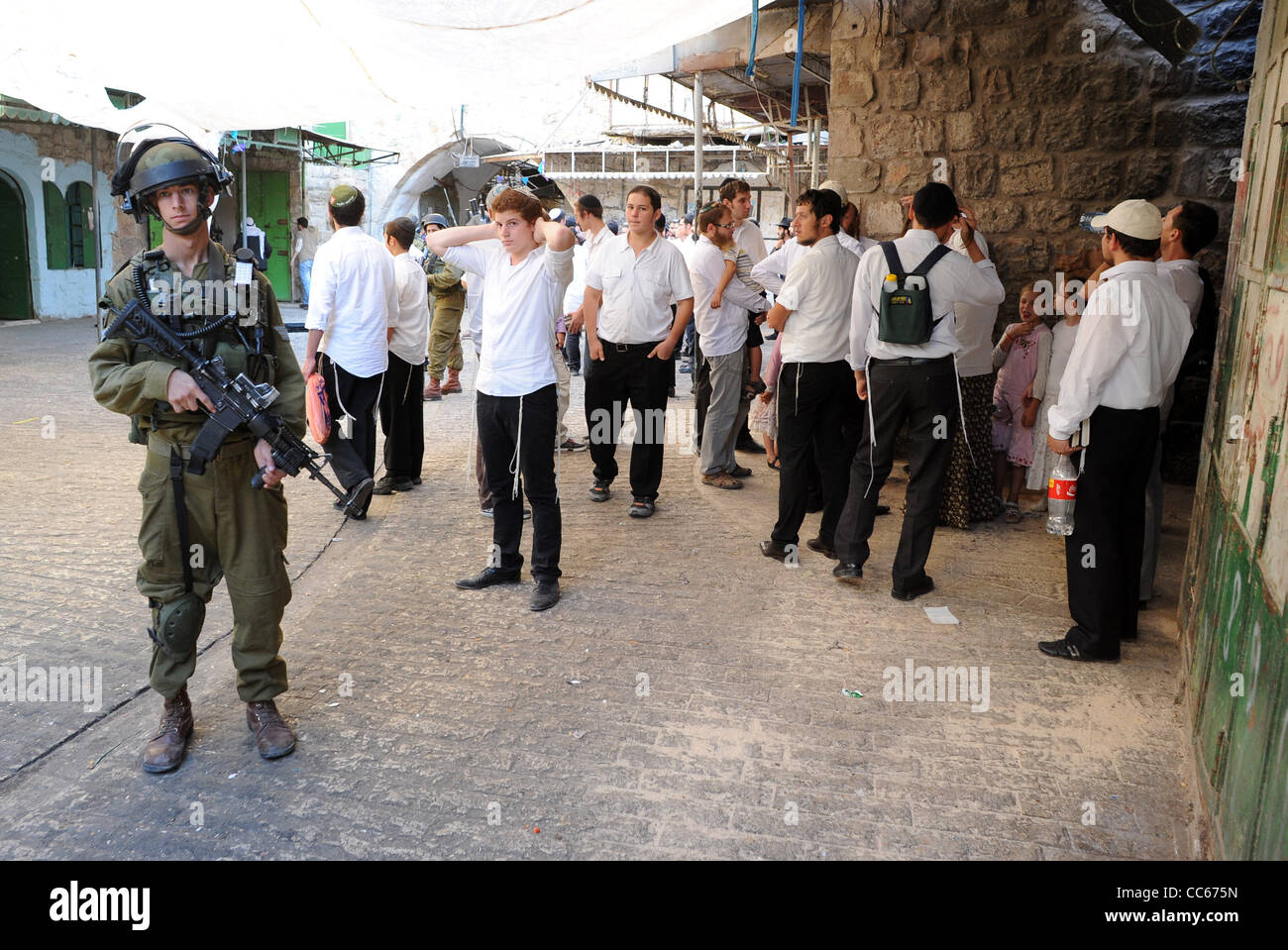 Soldati israeliani in pattuglia nella città vecchia di Hebron per accompagnare un gruppo di coloni ebrei. Foto Stock