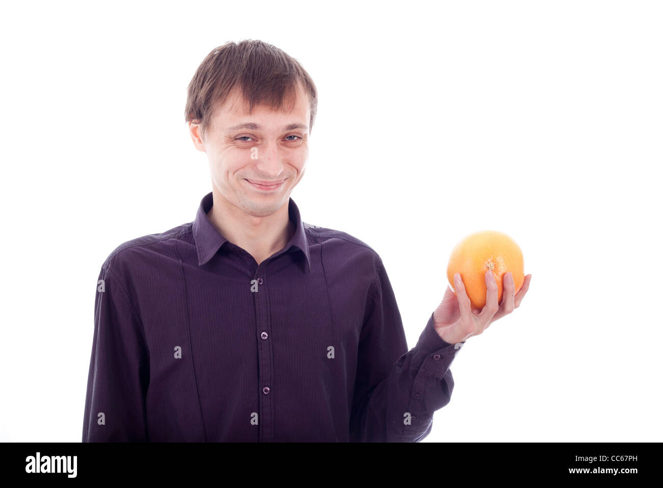 L'uomo faccia wry grimace azienda frutta acerba, isolare su sfondo bianco. Foto Stock