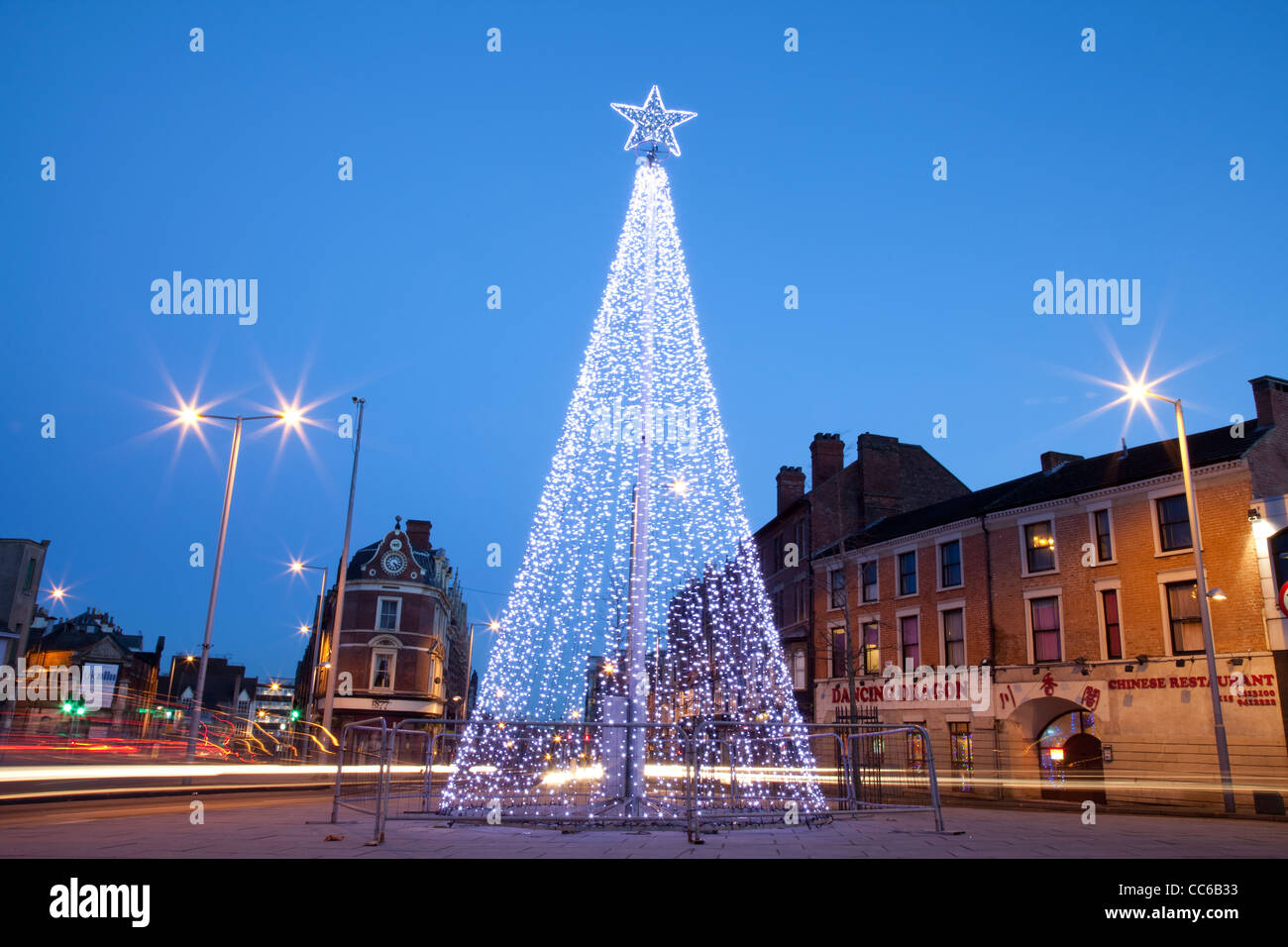 L'accensione di un albero di Natale con Stella sulla parte superiore di notte con auto sentieri di luce Nottingham England Regno Unito Foto Stock