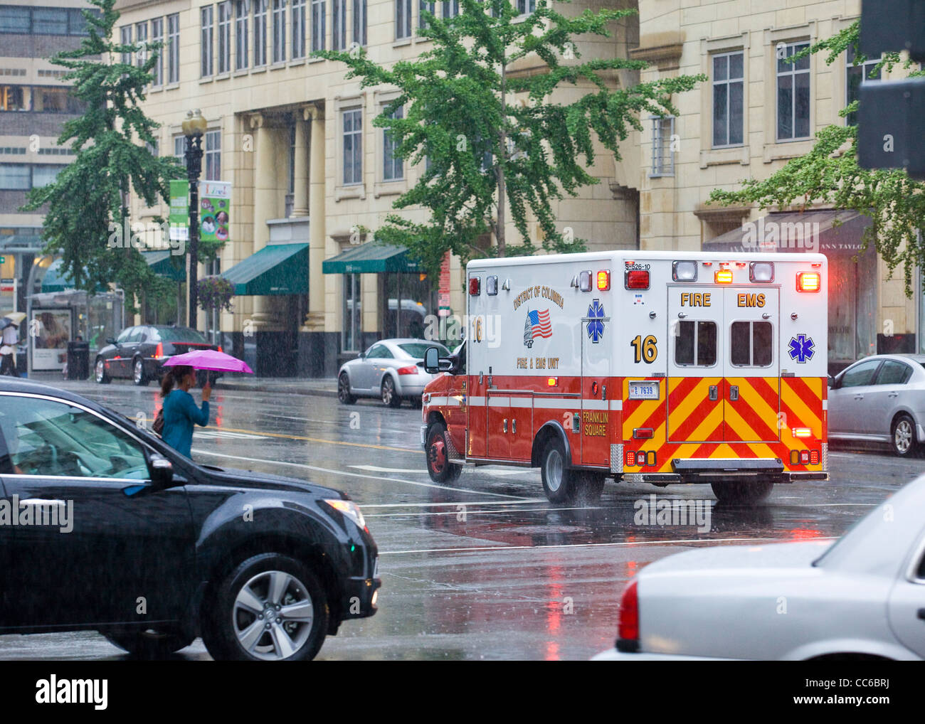 Un ambulanza racing giù per una strada di città in un giorno di pioggia - USA Foto Stock