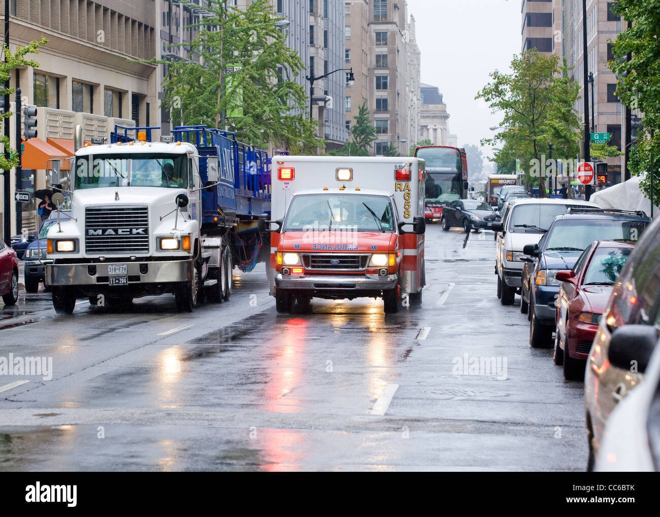 Un ambulanza racing giù per una strada di città in un giorno di pioggia - Washington DC, Stati Uniti d'America Foto Stock
