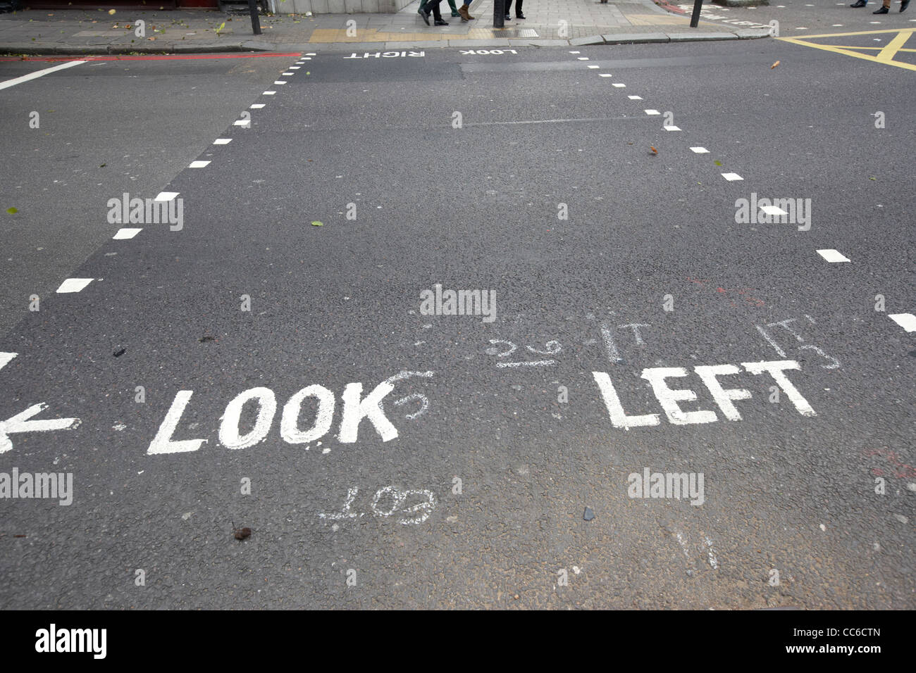 Guardare a sinistra dipinta sulla strada in corrispondenza di un attraversamento pedonale in Londra England Regno Unito Regno Unito Foto Stock