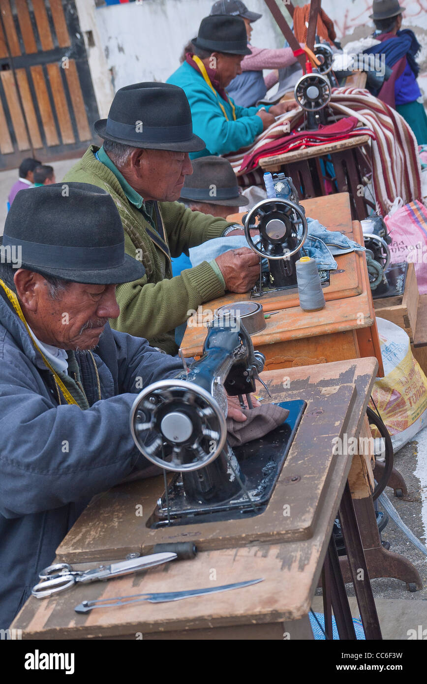 Quattro vecchi uomini ecuadoriana cucire sul vecchio pedale macchine per cucire al di fuori nel famoso mercato di Saquisili, Ecuador. Foto Stock