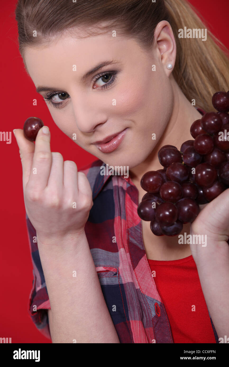 Donna attraente mangiare uva Foto Stock