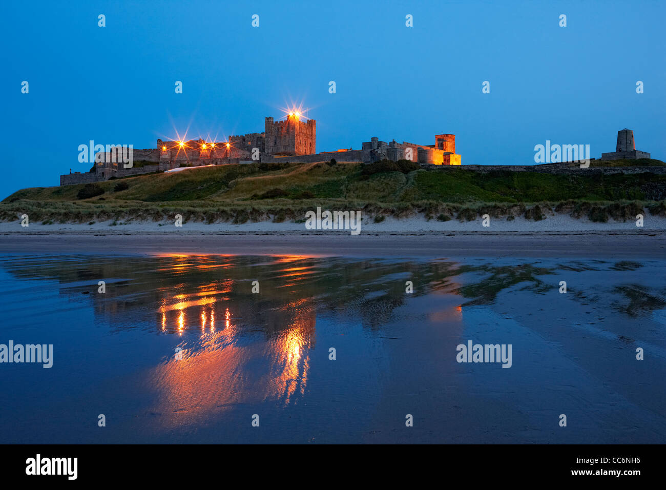 Il castello di Bamburgh dalla spiaggia, a tarda sera. Foto Stock