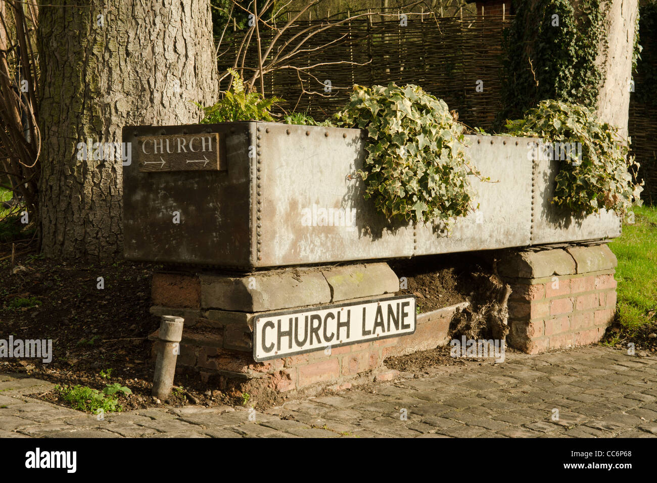 Una lamiera zincata abbeveratoio ora utilizzato come un contenitore per la coltivazione di piante e fiori in Church Lane Great Missenden Bucks REGNO UNITO Foto Stock