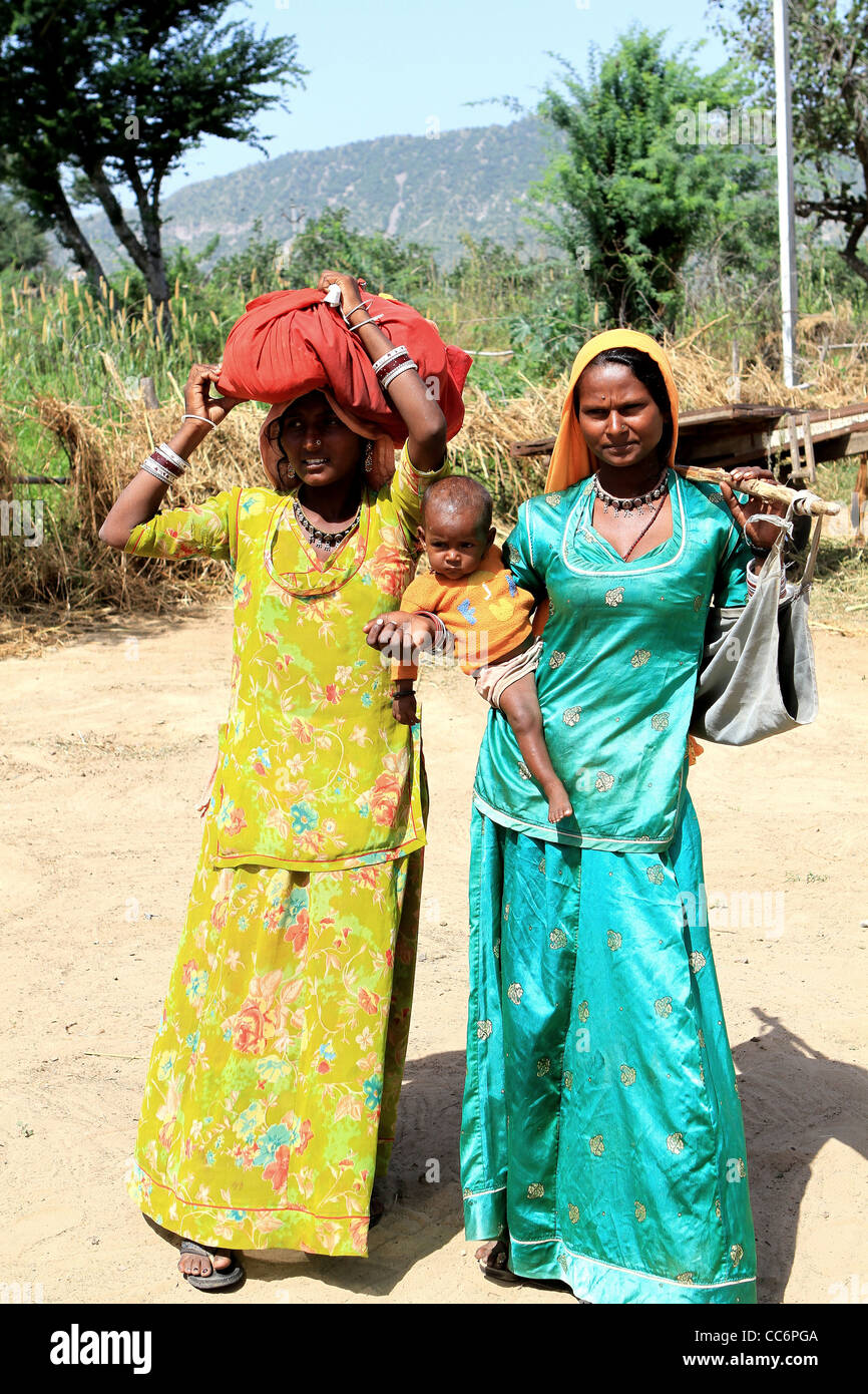 2 villaggio indiano le donne con il bambino in variopinti costumi tradizionali Foto Stock