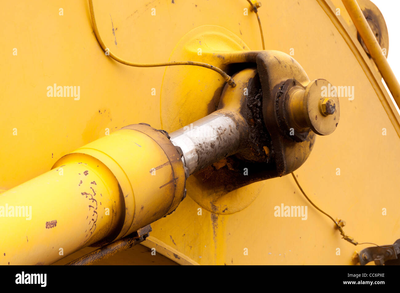 Un cilindro idraulico dipinto di giallo con un asta di cromo Foto Stock