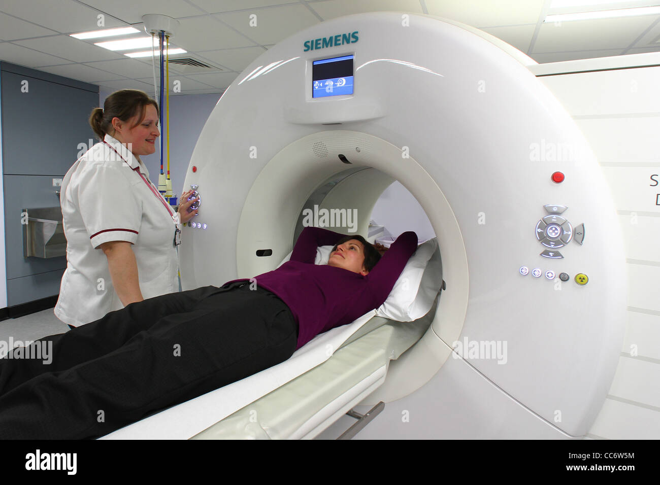 Una giovane donna entra in uno scanner TC in ospedale Addenbrookes in Cambridgeshire Foto Stock