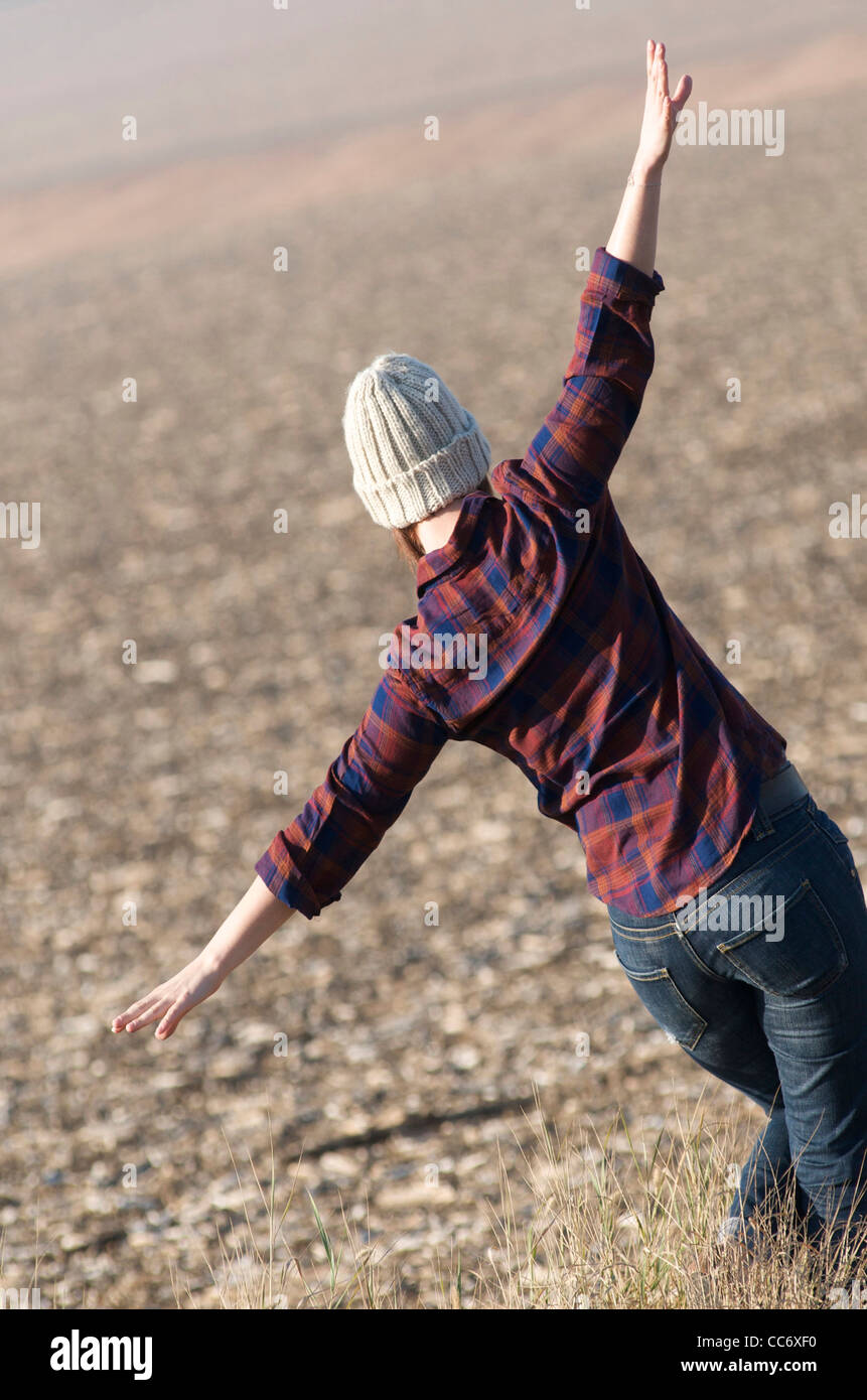 Felice giovane donna camminare in un campo in campagna Foto Stock