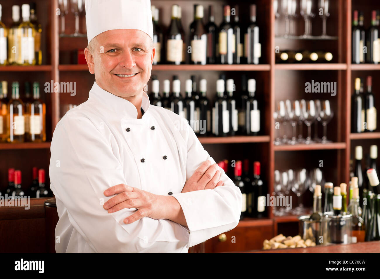 Chef di cucina professionale fiducioso in posa ristorante bracci trasversali Foto Stock