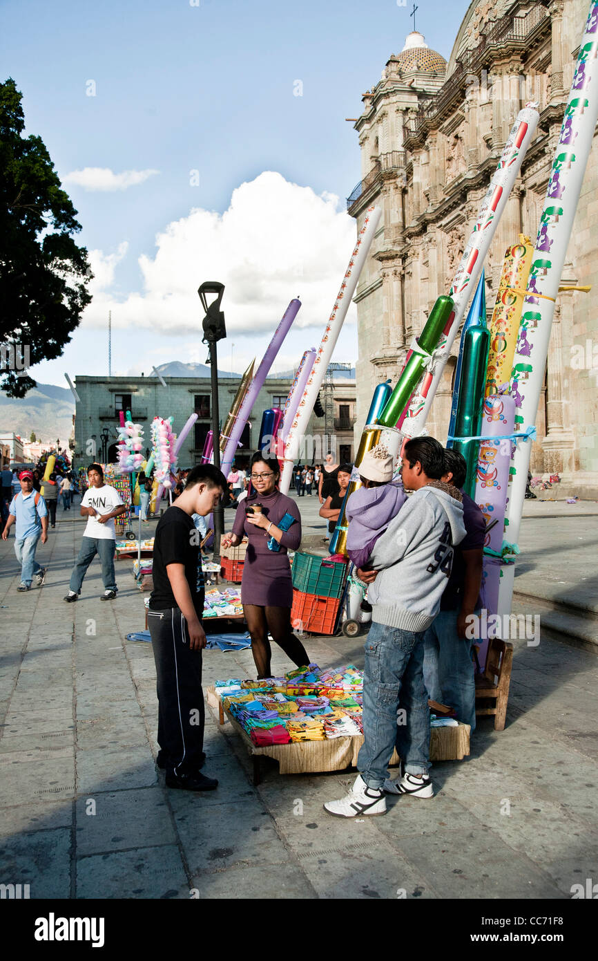 Messicano sindrome Downs ragazzo adolescente con abbastanza sorridente sorella seleziona palloncino a siluro dal fornitore esterno Cattedrale di Oaxaca Foto Stock