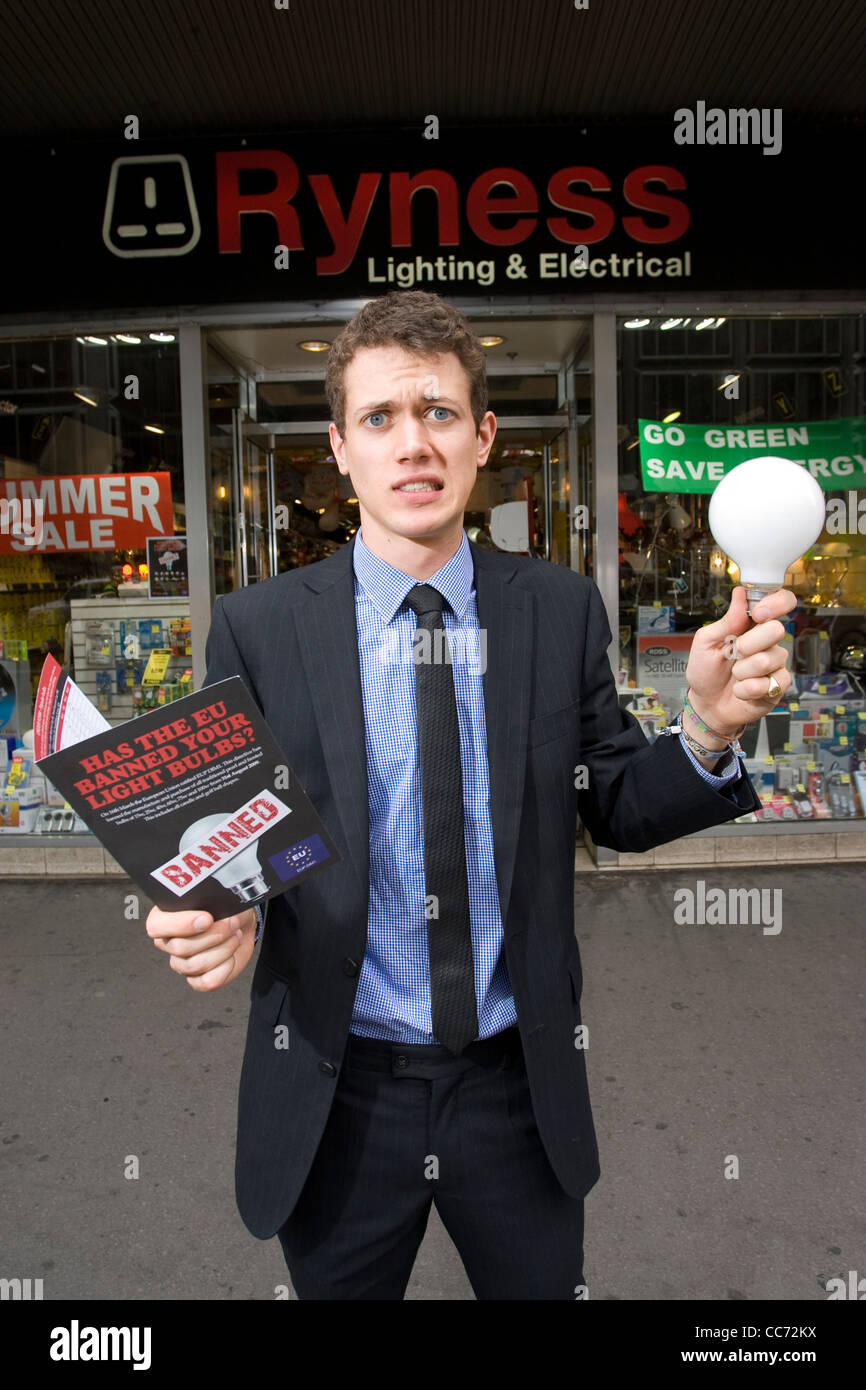 L'uomo contempla che tipo di lampadina per acquistare in negozio elettrica come energia-luce inefficiente le lampadine possono essere eliminate gradualmente. Foto Stock