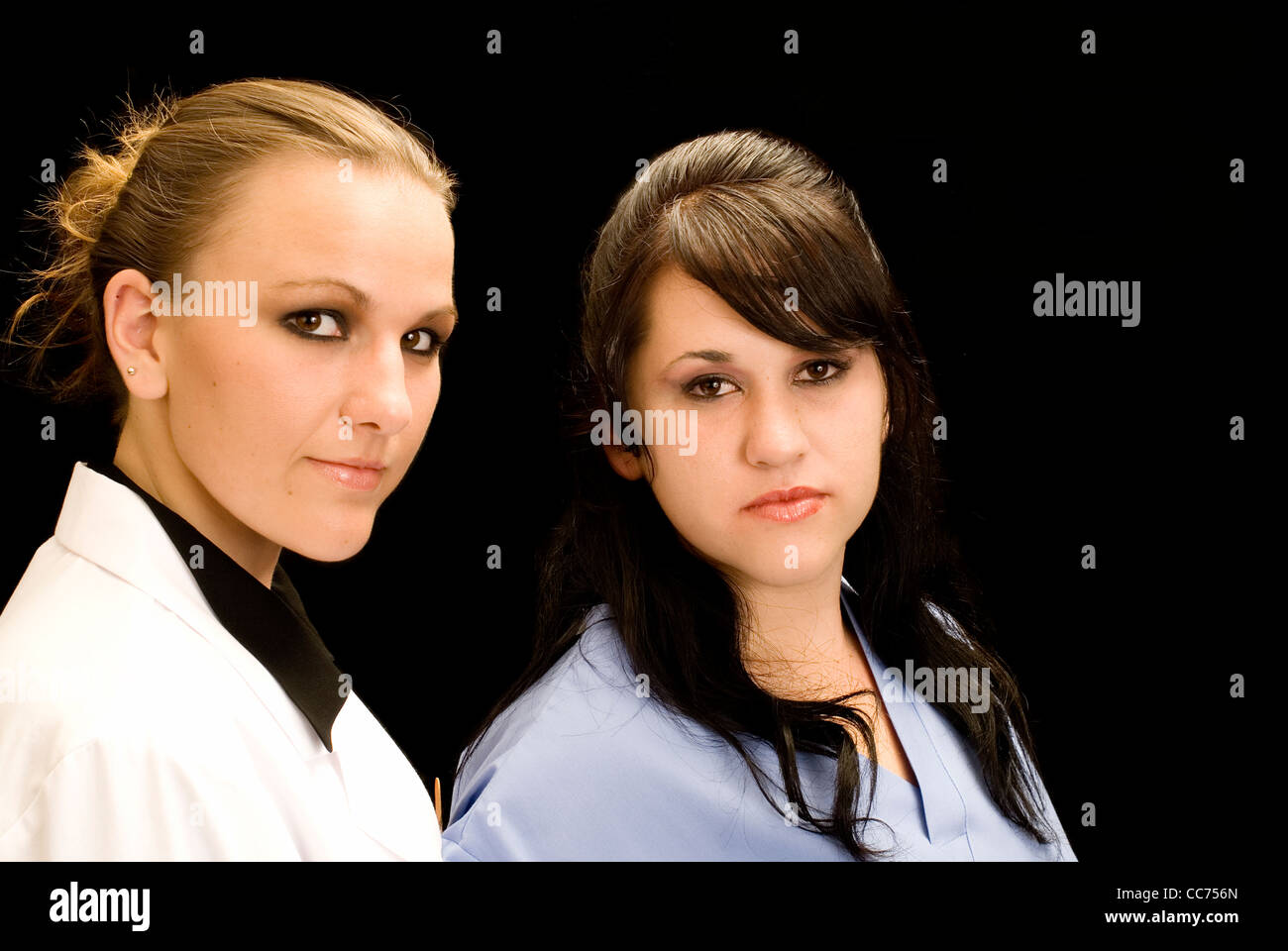 Due donne professionisti sanitari (medici o infermieri) isolato su nero. Foto Stock