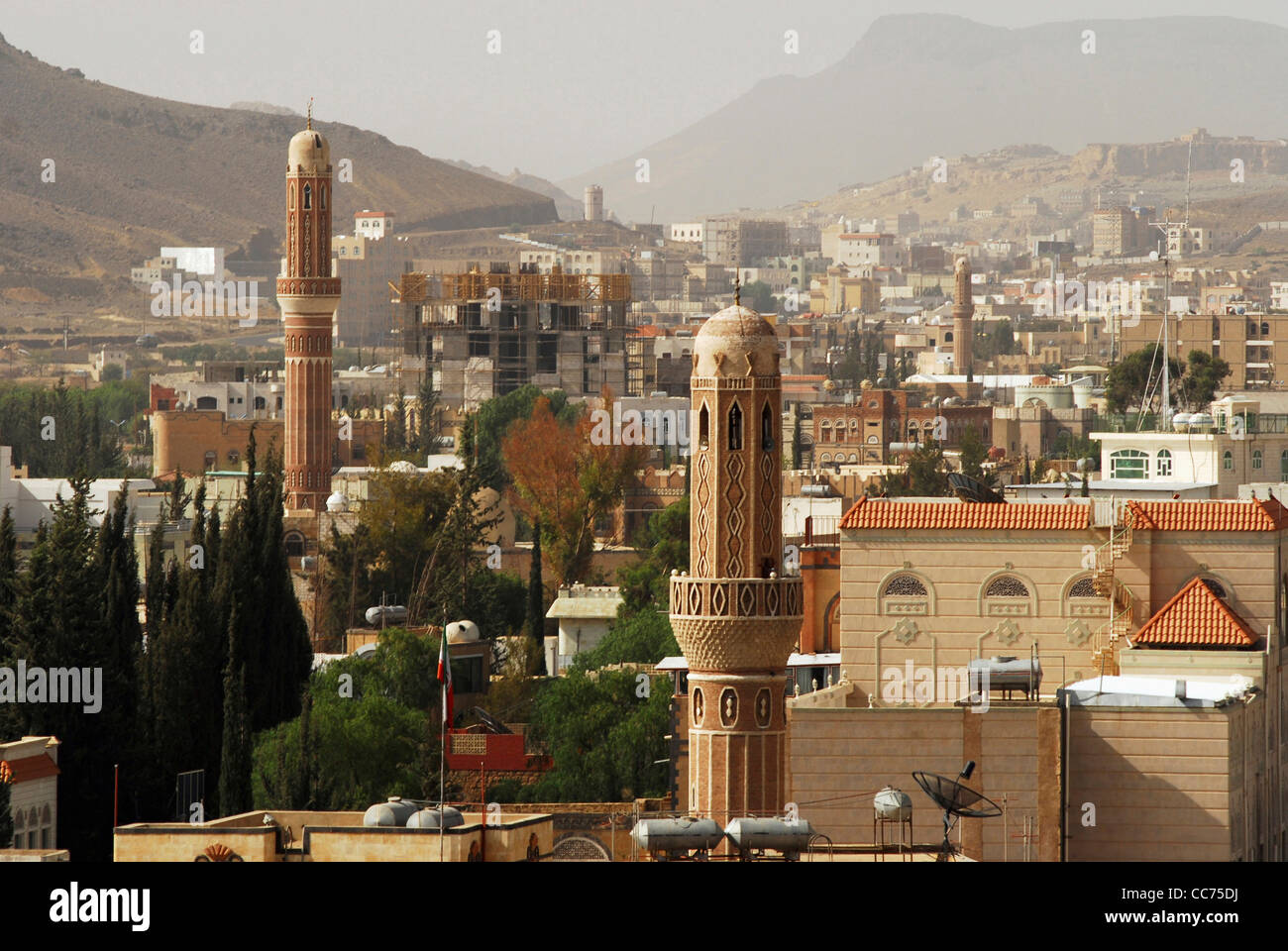 Yemen, Sanaa, vista in elevazione della antica alti minareti marrone con il paesaggio e le montagne sullo sfondo Foto Stock