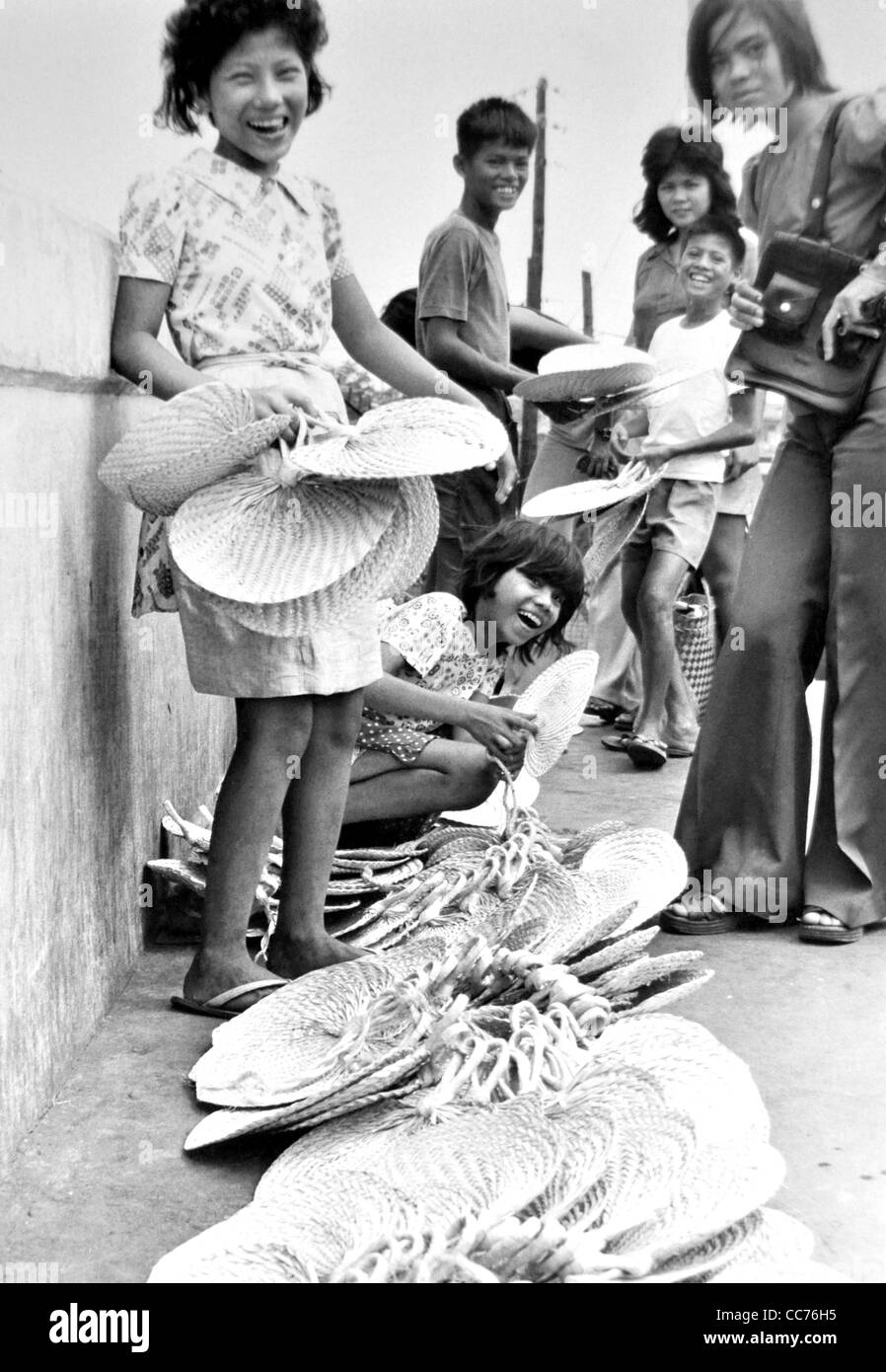 Chreeful giovani vendere i fan di tessuto in una Manila street market. Filippine Foto Stock