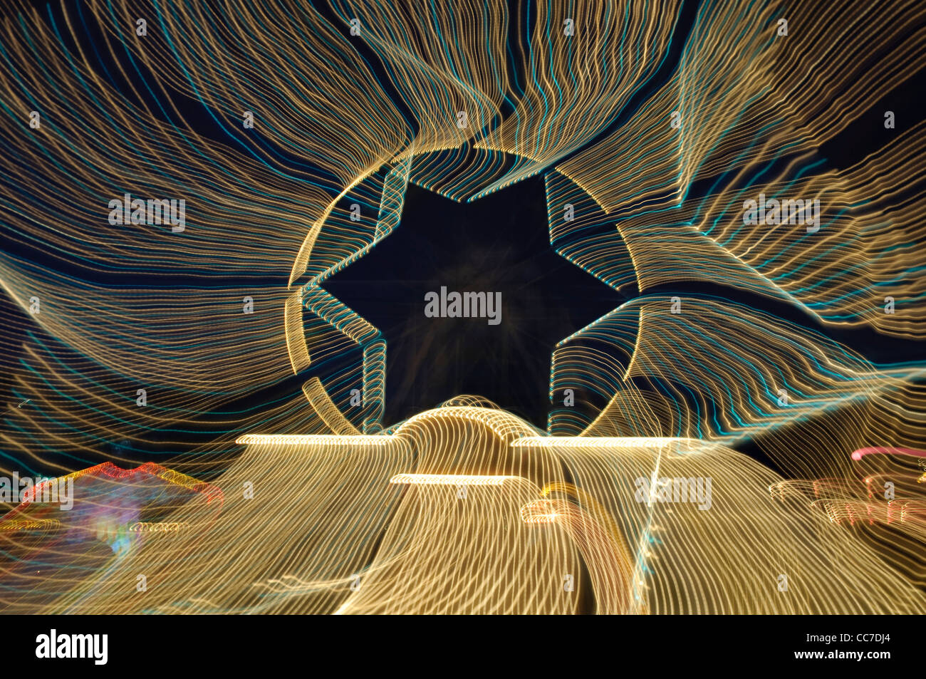 Percorsi di luce con una forma a stella, ruota panoramica Ferris, giostra Foto Stock
