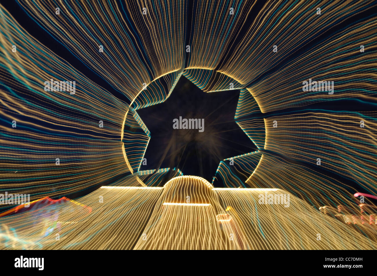 Percorsi di luce con una forma a stella, ruota panoramica Ferris, giostra Foto Stock