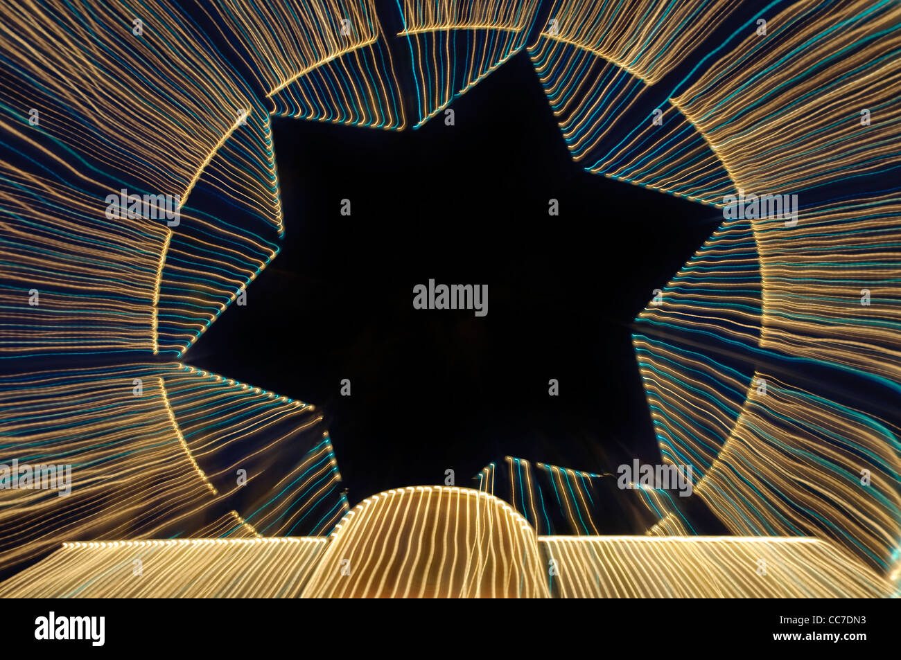 Percorsi di luce con una forma a stella, ruota panoramica Ferris, giostra Foto Stock