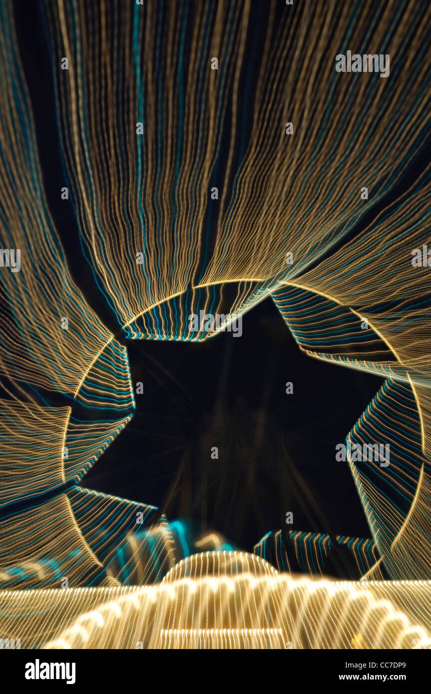 Percorsi di luce con una forma a stella, ruota panoramica Ferris, giostra Foto Stock