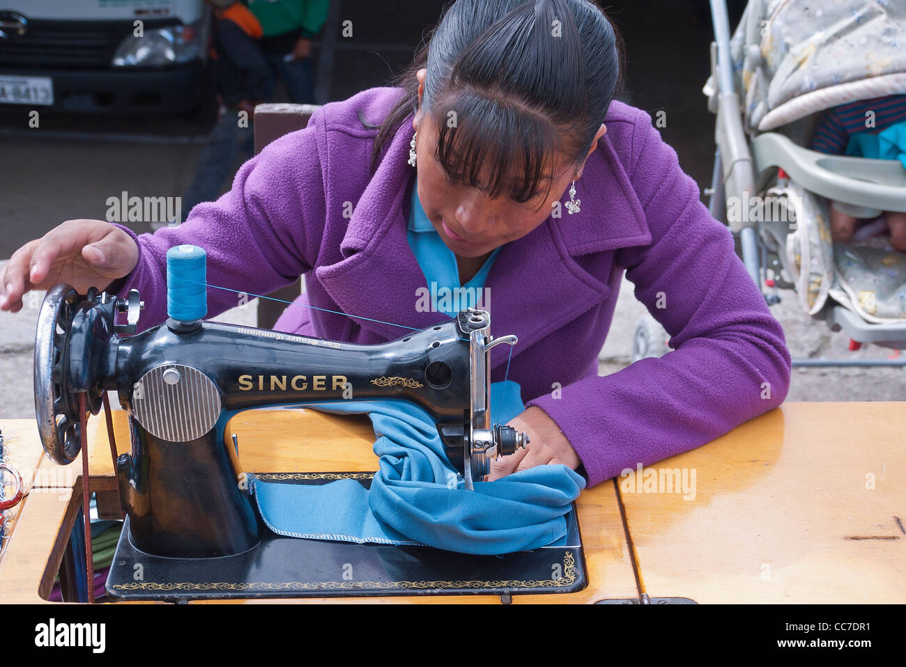 Un adolescente cuce sul suo stile vecchia Singer macchina da cucire nel mercato di Saquisili, Ecuador. Foto Stock