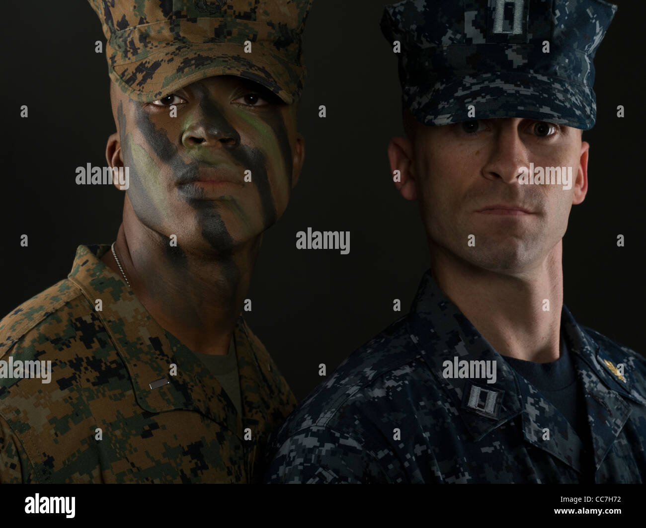 Stati Uniti Marine Corps Officer in MARPAT digital camouflage uniforme e faccia camo vernice con ufficiale navale della Marina Militare in uniforme di lavoro Foto Stock