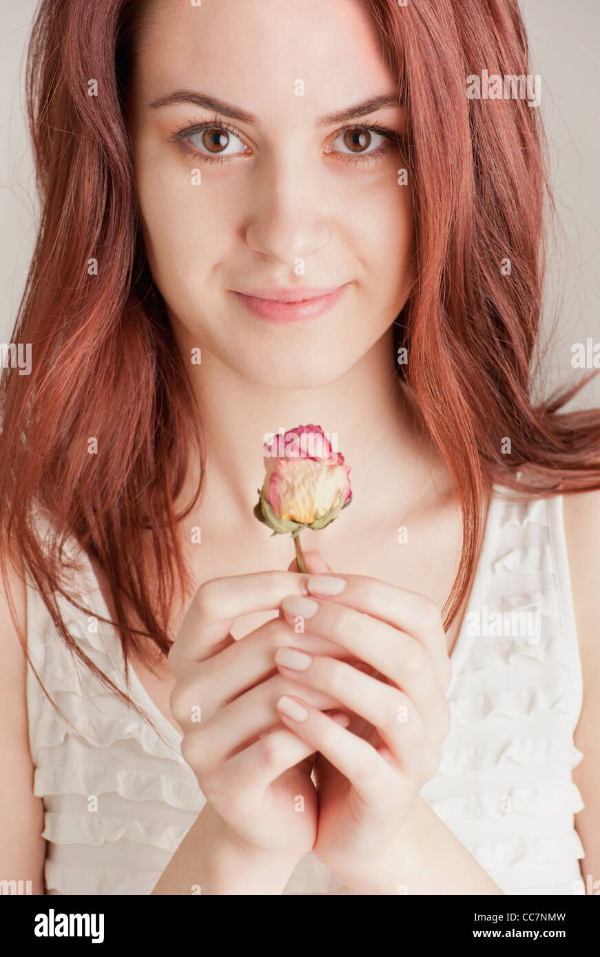 Giovane donna tenendo una rosa Foto Stock