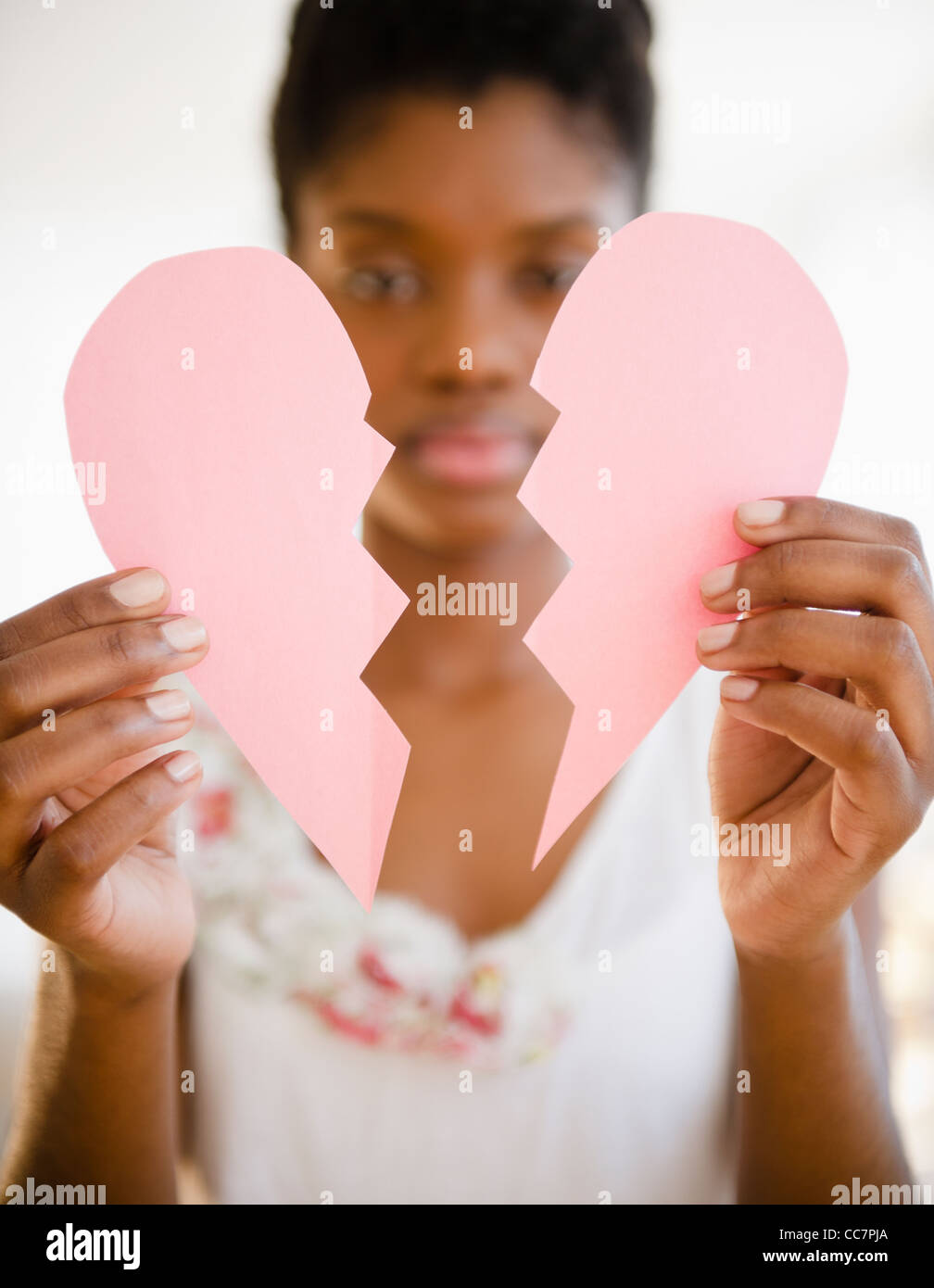 Nero donna holding rotto cuore di carta Foto Stock