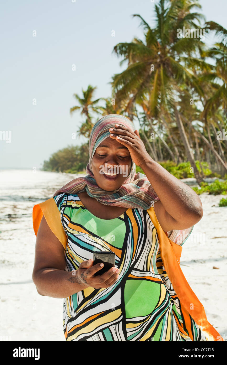 Donna che guarda le istantanee, Nyota Beach, Unguja, Zanzibar, Tanzania Foto Stock