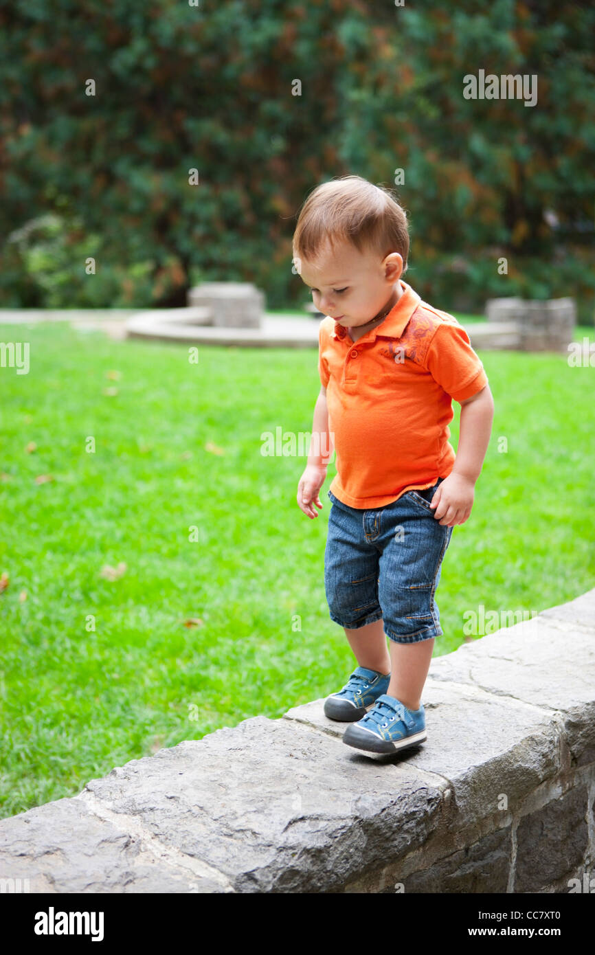 Ragazzo camminando sul muro di pietra, Washington Park, Portland, Oregon, Stati Uniti d'America Foto Stock