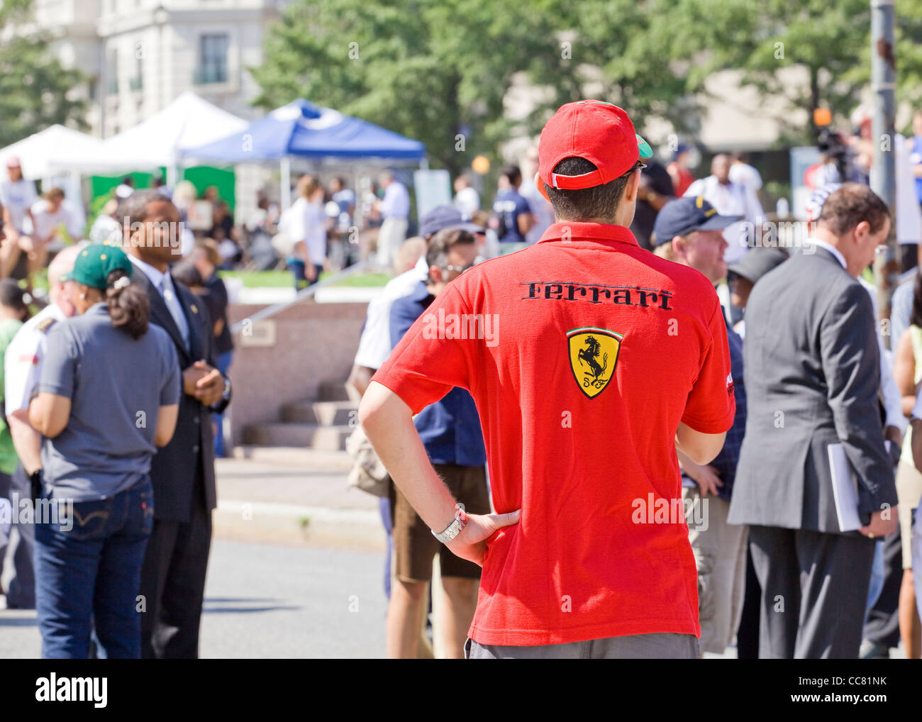 Un uomo che indossa una maglietta della Ferrari e il tappo in corrispondenza di un evento esterno Foto Stock