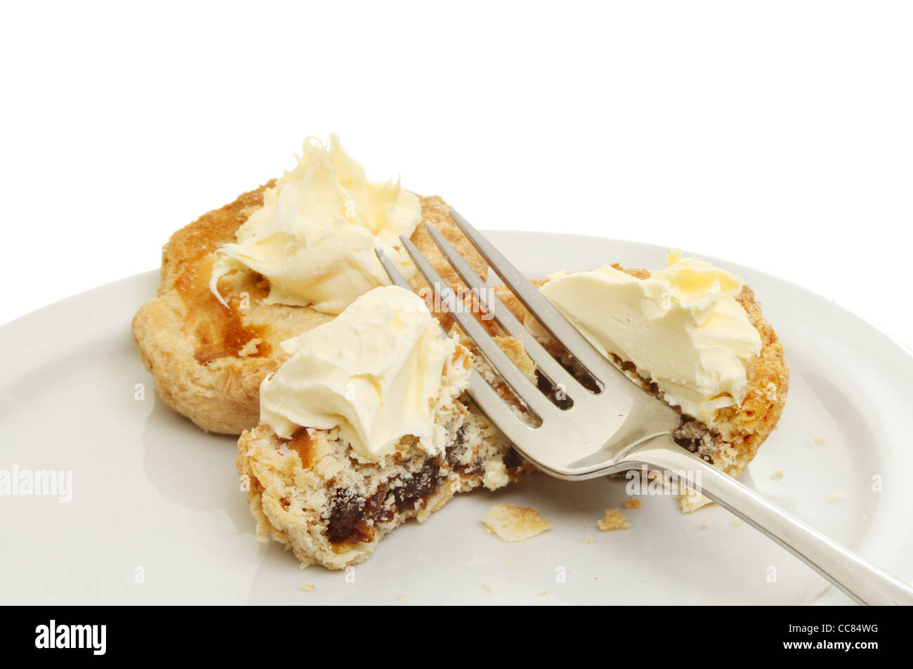 Torte di carne macinata e clotted cream con una forcella su una piastra contro uno sfondo bianco Foto Stock