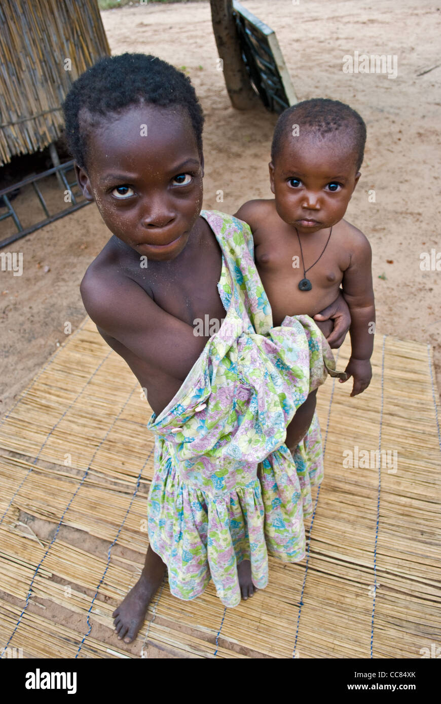 Una ragazza dello Zambia trattiene il suo piccolo fratello. Foto Stock