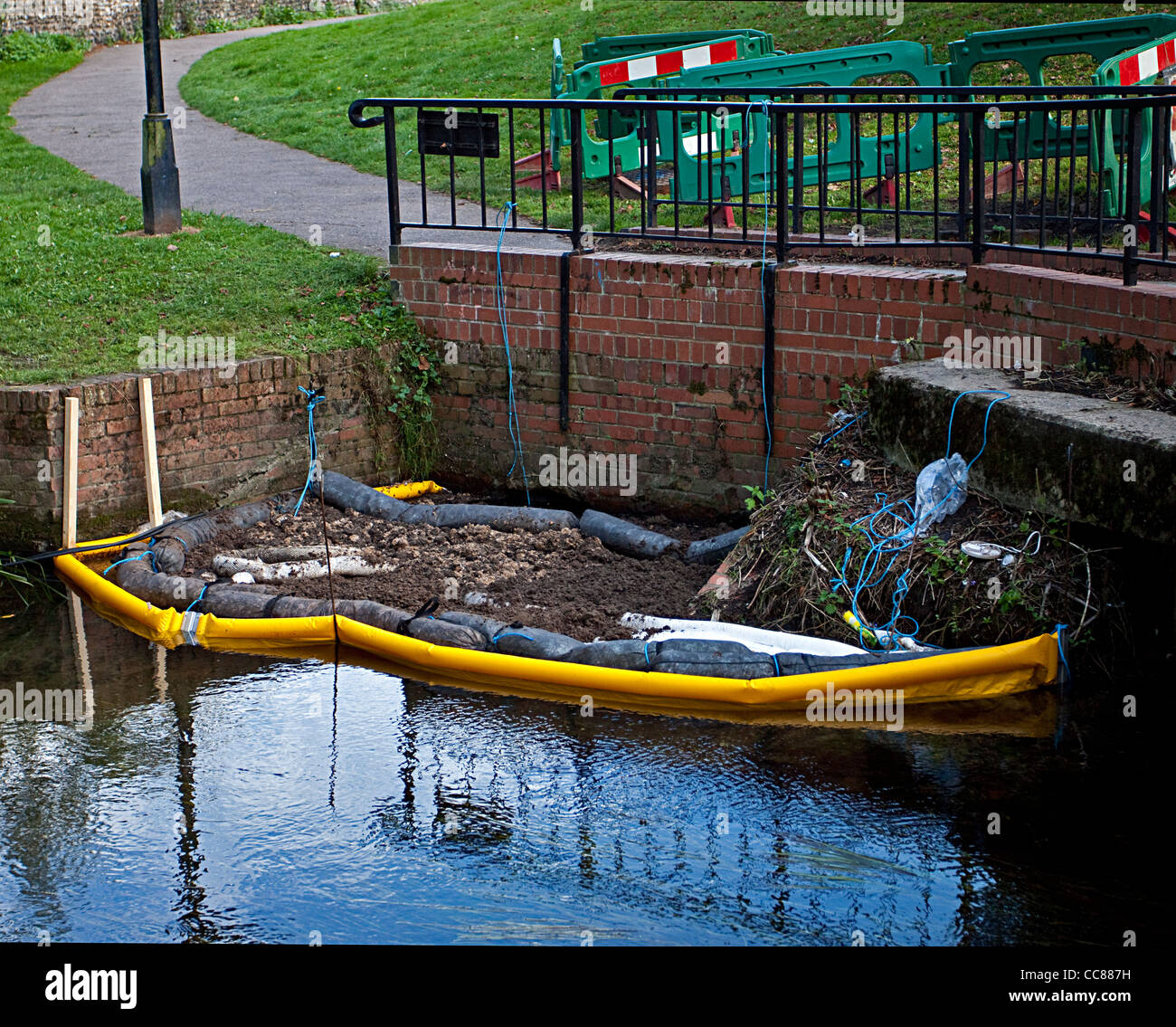 Marea nera fuoriuscita inquinamento nel fiume controllo dell inquinamento ambientale i bracci dell'olio olio granuli assorbenti in uso Foto Stock