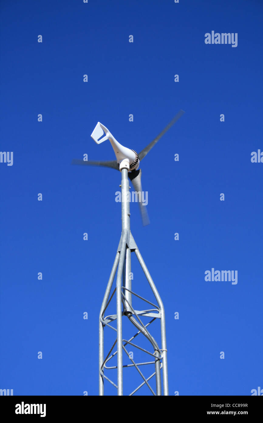 Un piccolo generatore elettrico mulino a vento contro un cielo blu Foto Stock