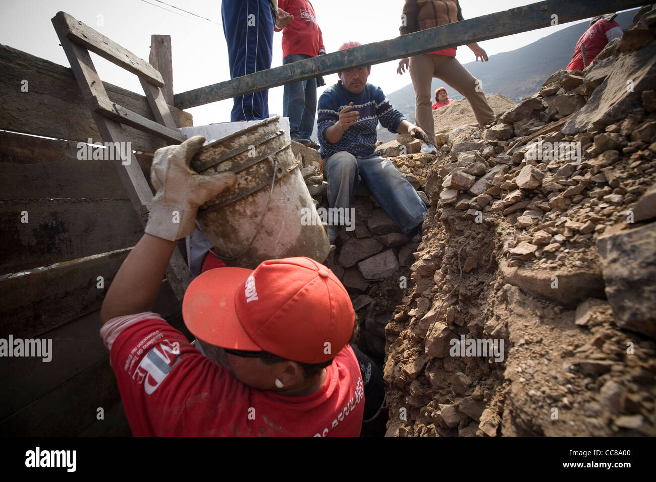 Un equipaggio di costruzione costruisce una nuova parete lungo il pendio di una collina in Lima, Perù, Sud America. Foto Stock