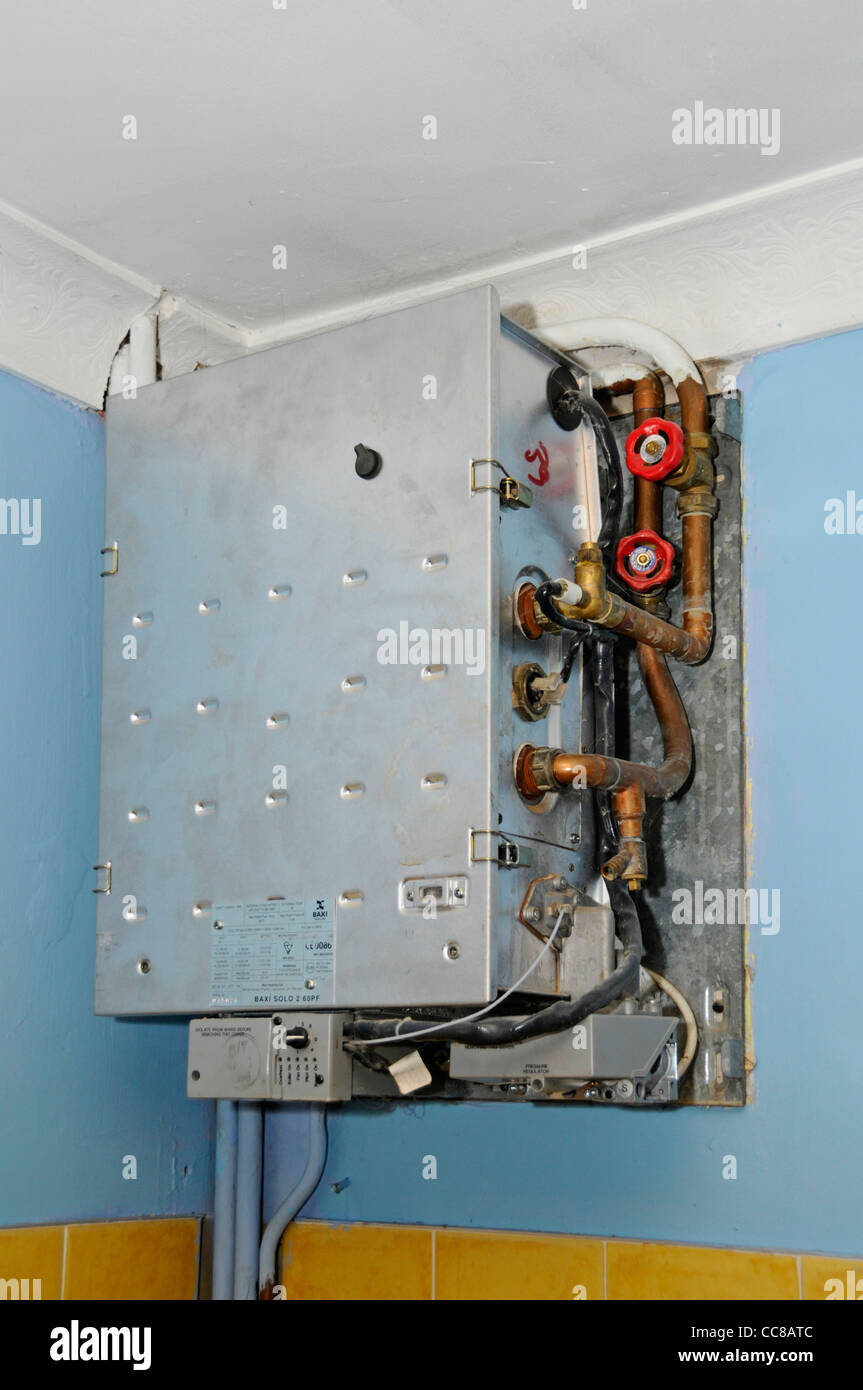 Rotto obsoleto il vecchio domestico caldaia a gas in procinto di essere rimossa e sostituita con una nuova versione di condensazione (vedere immagine Alamy CC8ATN) Foto Stock