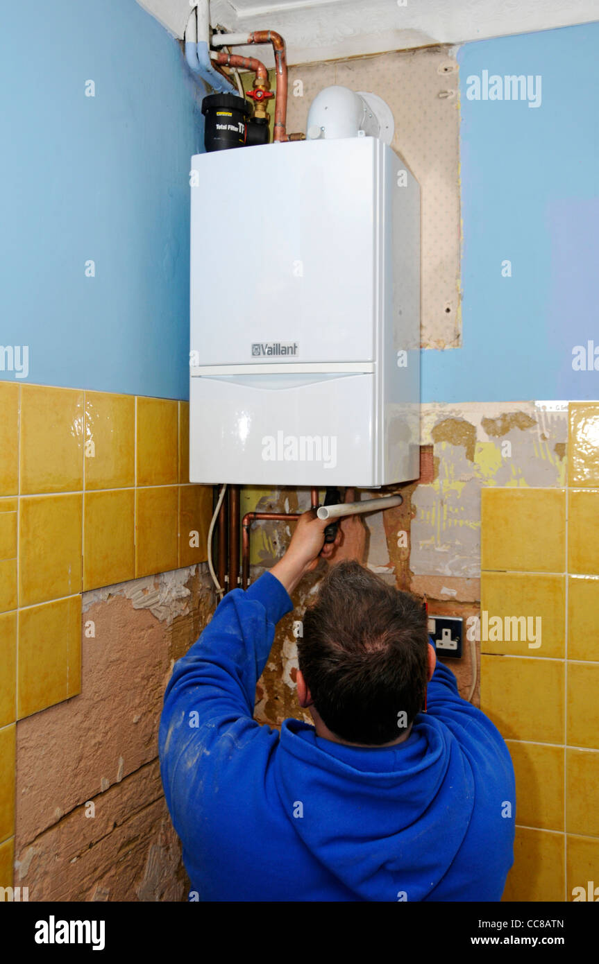 Condensazione caldaia a gas sono installati da plumber uomo per sostituire il vecchio guasto unità (vedere Alamy info aggiuntive pannello) parte della cucina home improvement REGNO UNITO Foto Stock