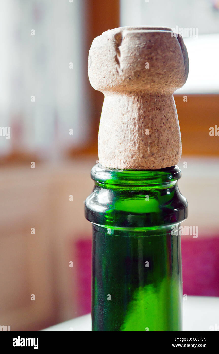 Aprire il tappo di champagne su un verde bottiglia Foto Stock