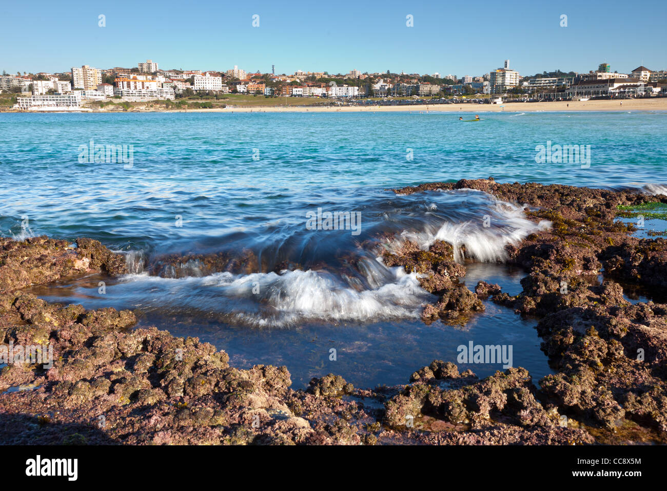 Onde su scogli a Bondi Beach a Sydney Foto Stock