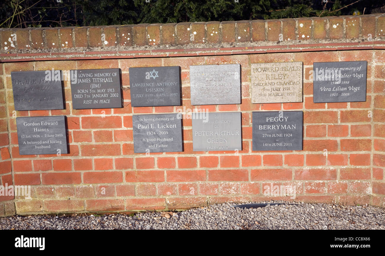 Lapidi sul muro di mattoni nel cimitero Foto Stock