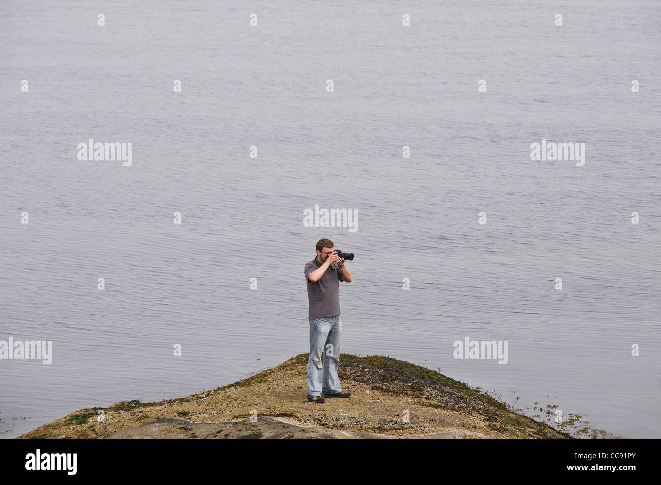 Fotografo in riva al mare Foto Stock