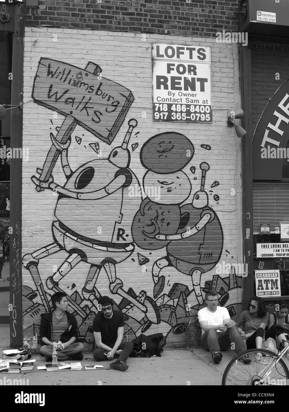 Persone di sedersi di fronte arte murale, Brooklyn, New York Foto Stock