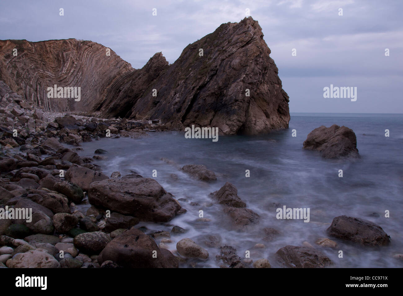 Foro di scale: l'inclinato "Lulworth Crumple" è un esempio da manuale di una roccia calcarea a forma di formazione da terra geologico piegatura. Il Dorset, Inghilterra, Regno Unito. Foto Stock