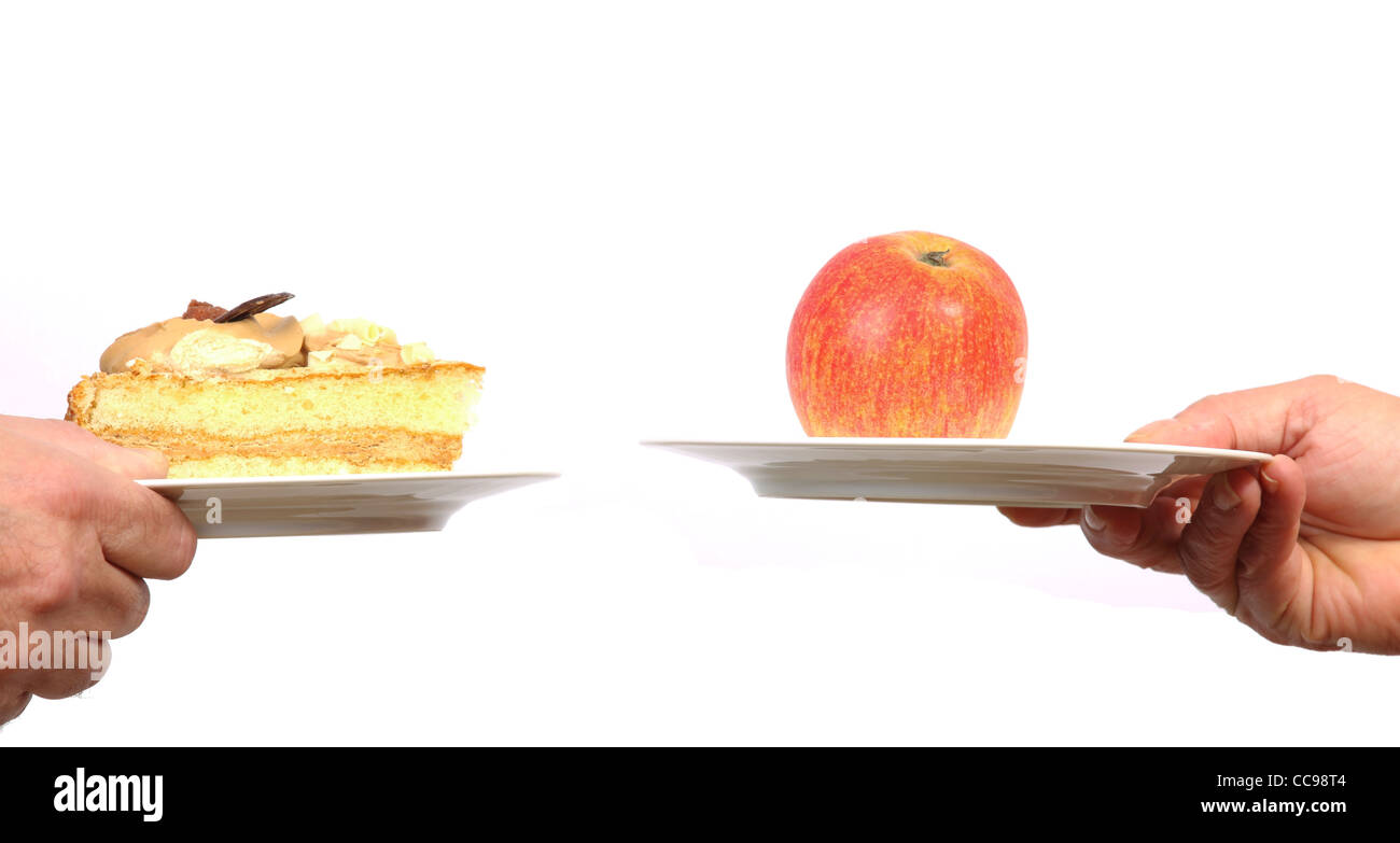 Effettuare una scelta fra una mela e un pezzo di torta Foto Stock