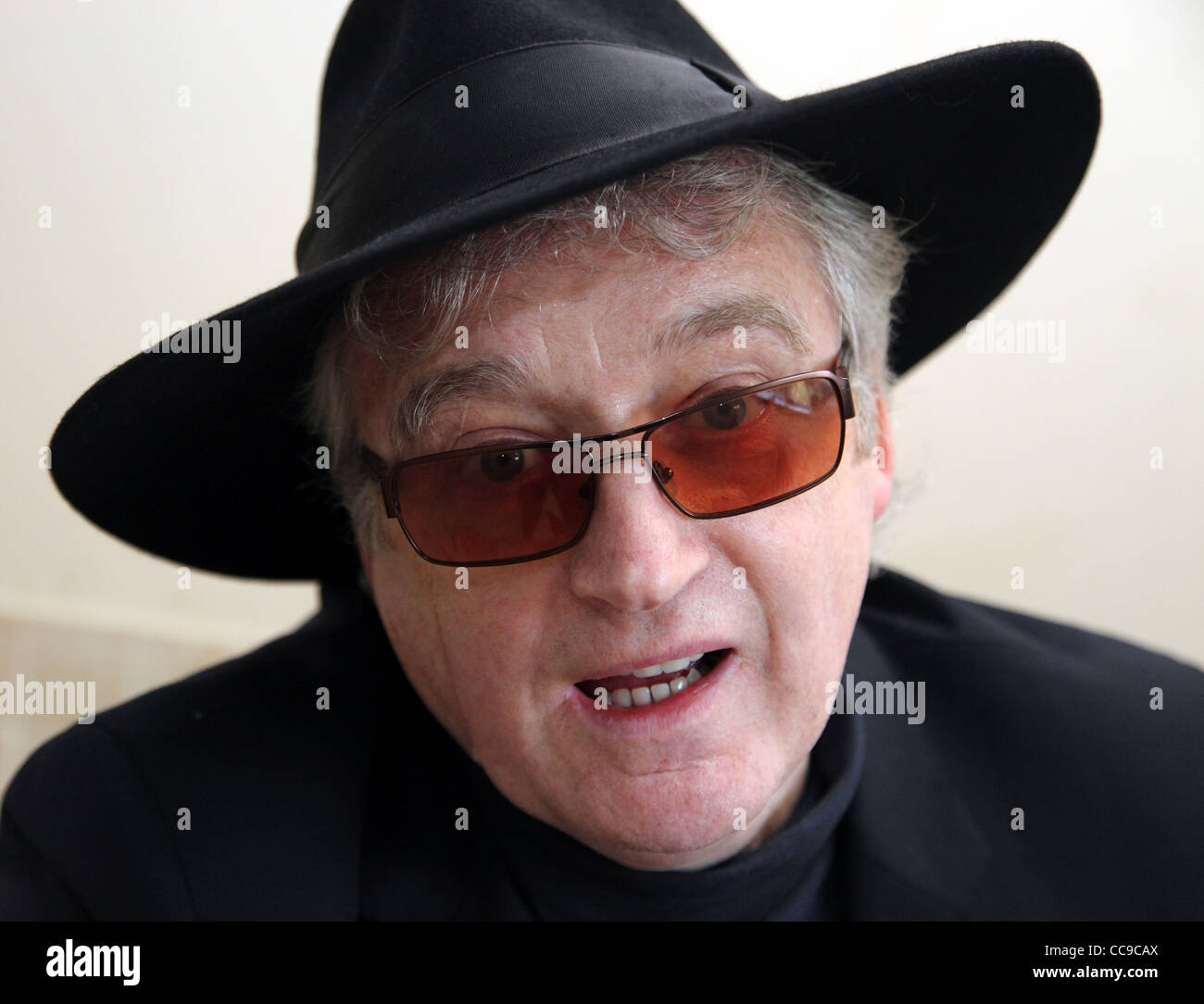Uomo in un cappello nero sostenendo Foto Stock