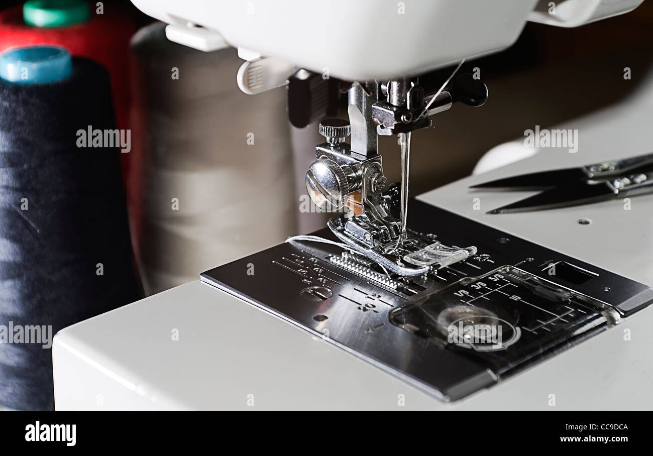 Meccanismo della macchina per cucire con ago e filo rocchetti sui thread di  background Foto stock - Alamy