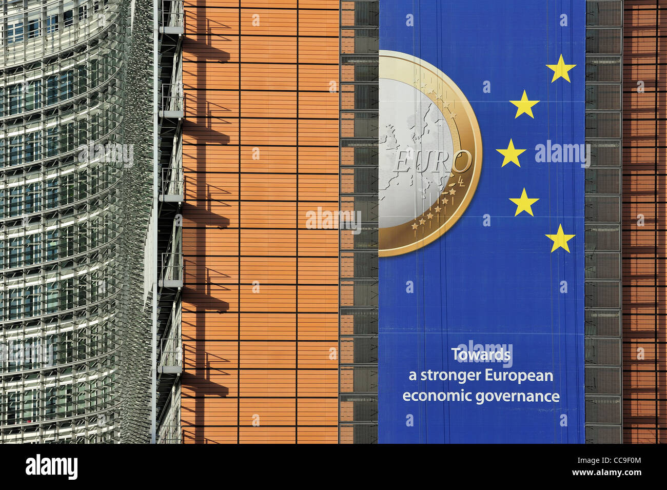 Banner sull'euro appesi da edificio della Commissione europea, organo esecutivo dell Unione Europea a Bruxelles, in Belgio Foto Stock