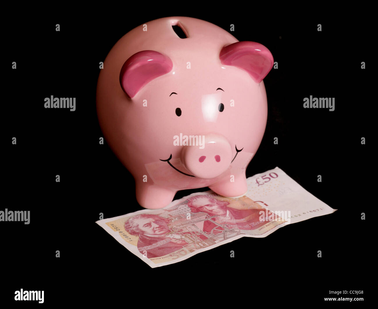 Piggybank con cinquanta pound nota su sfondo nero Foto Stock
