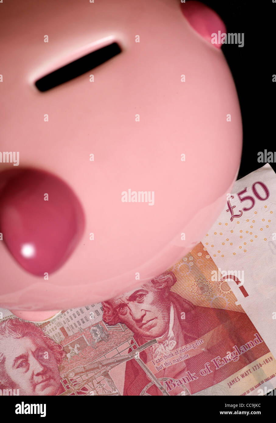 Piggybank con cinquanta pound nota su sfondo nero Foto Stock